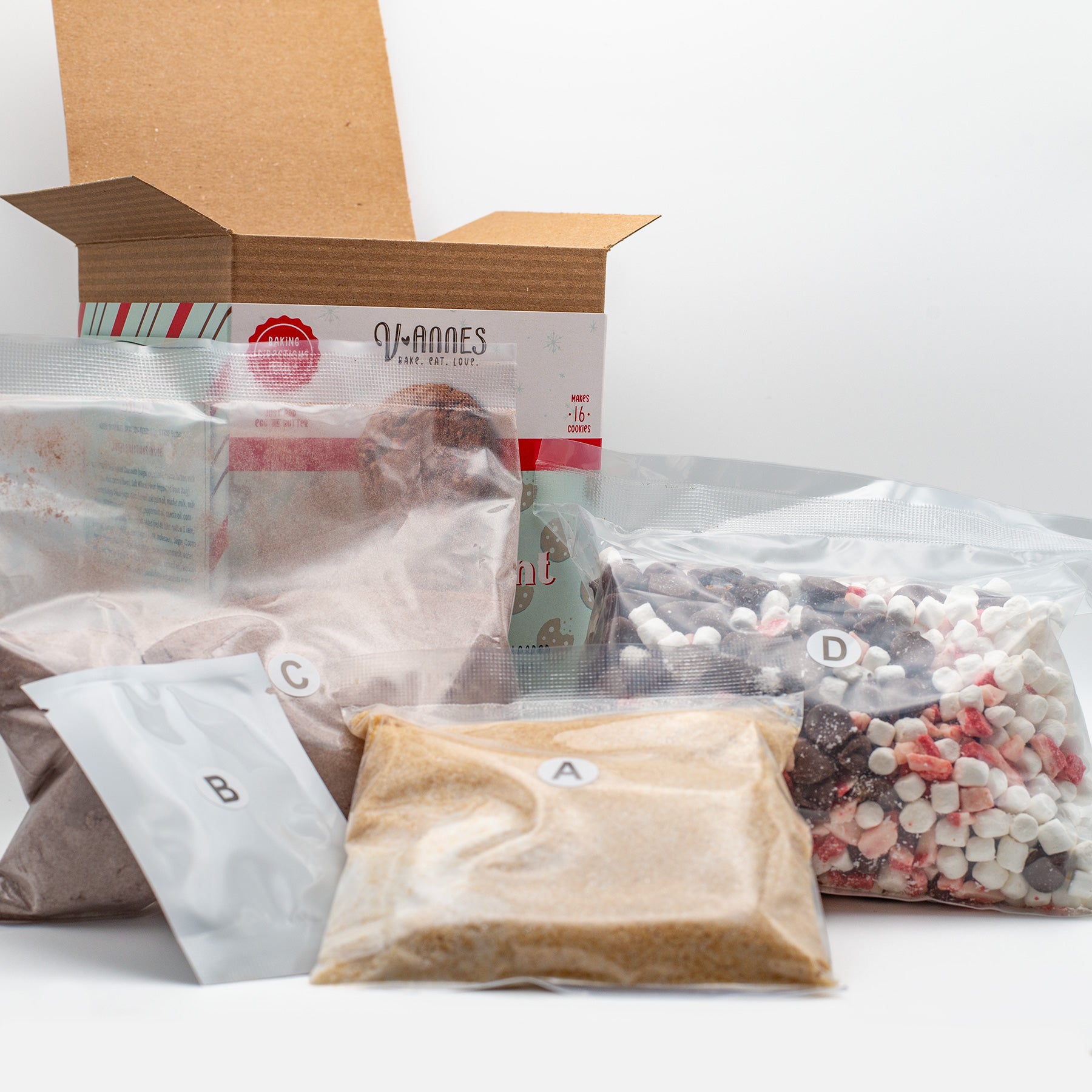 A box of V-annes Peppermint Bliss opened with marshmallows, and other packaged goods on a white background.